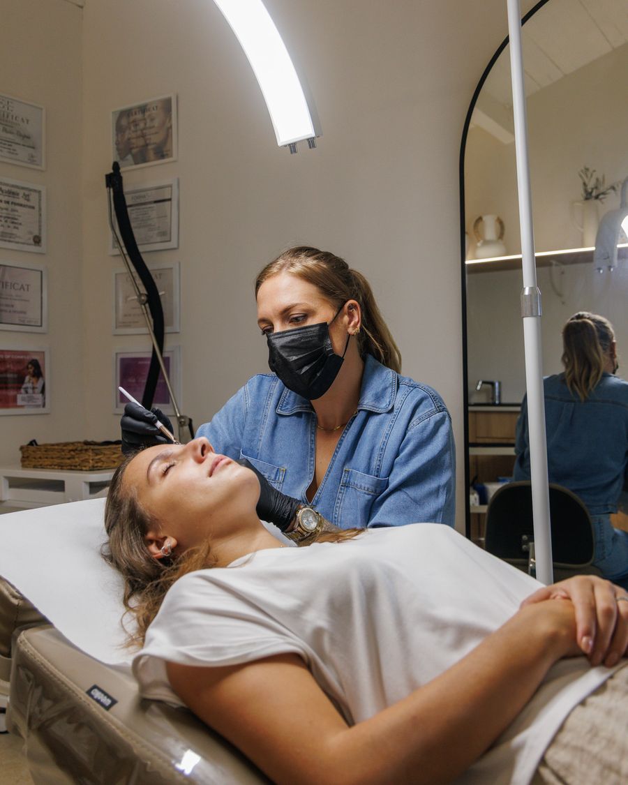Marie pendant une séance de dermopigmentation, certificats affichés en arrière-plan