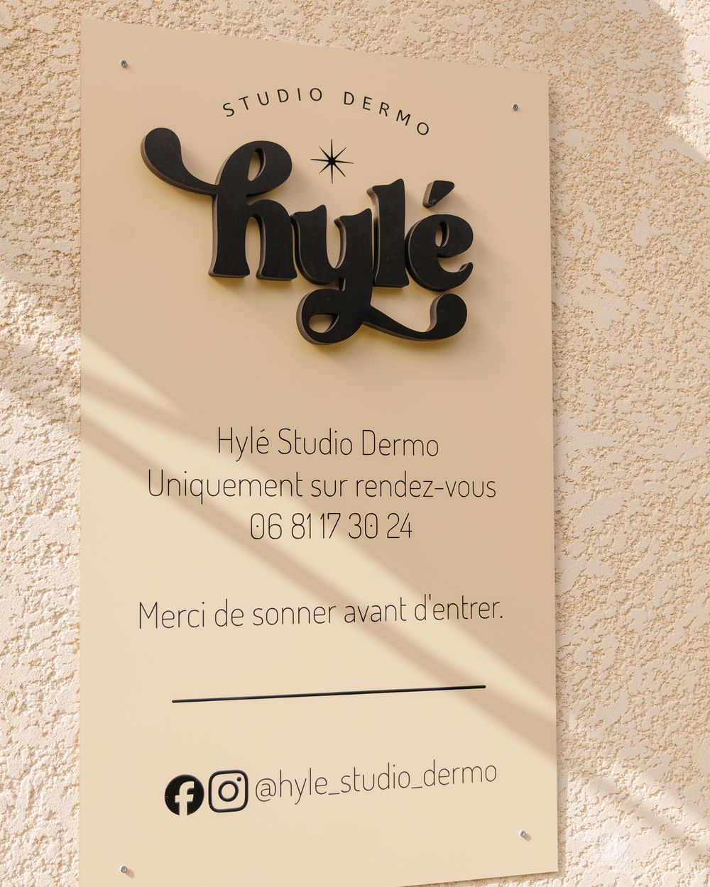 Plaque Hylé Studio Dermo sur la façade, à gauche de la maison, à Biguglia