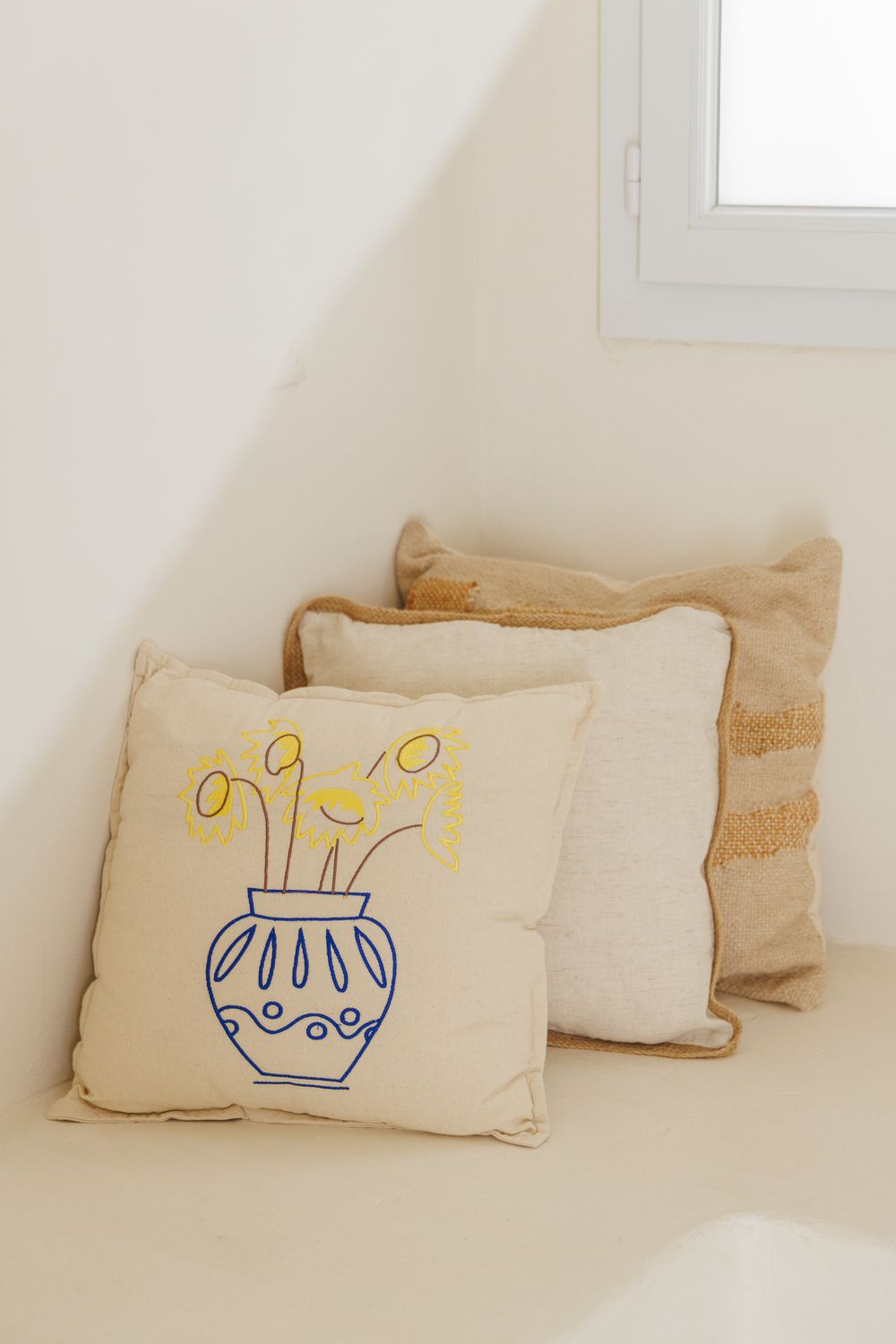 Coussins brodés d'inspiration grecque sur la banquette du studio Hylé