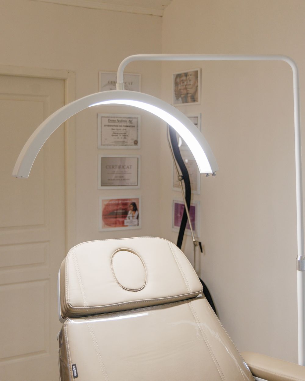 Fauteuil de soin, lampe et certificats de formation dans la cabine du studio Hylé